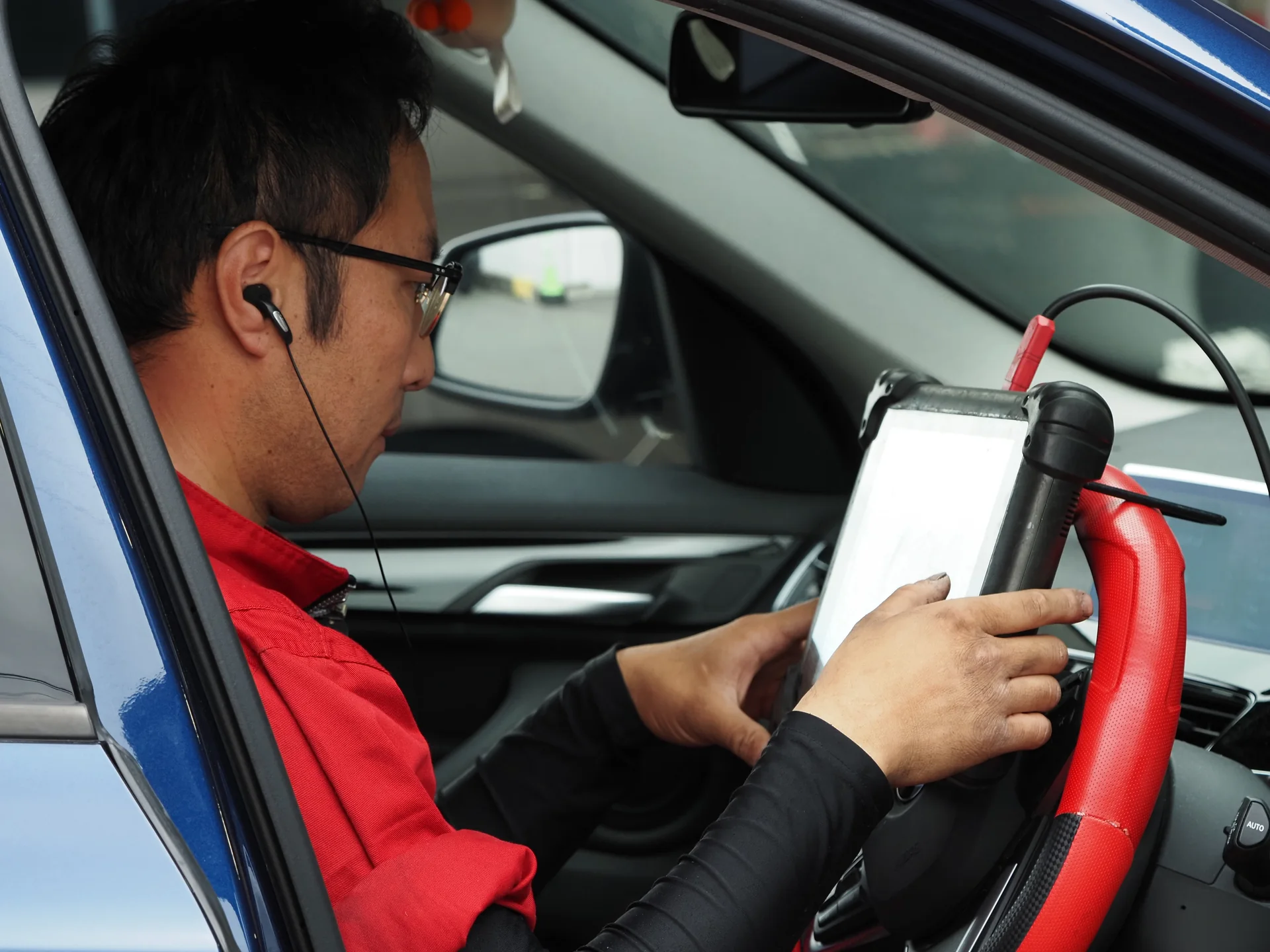 車内で診断機を使用するメカニック