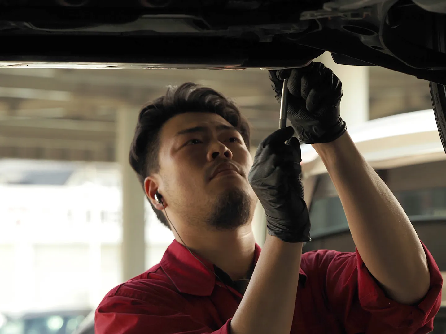 リフト下で車両を点検する作業風景